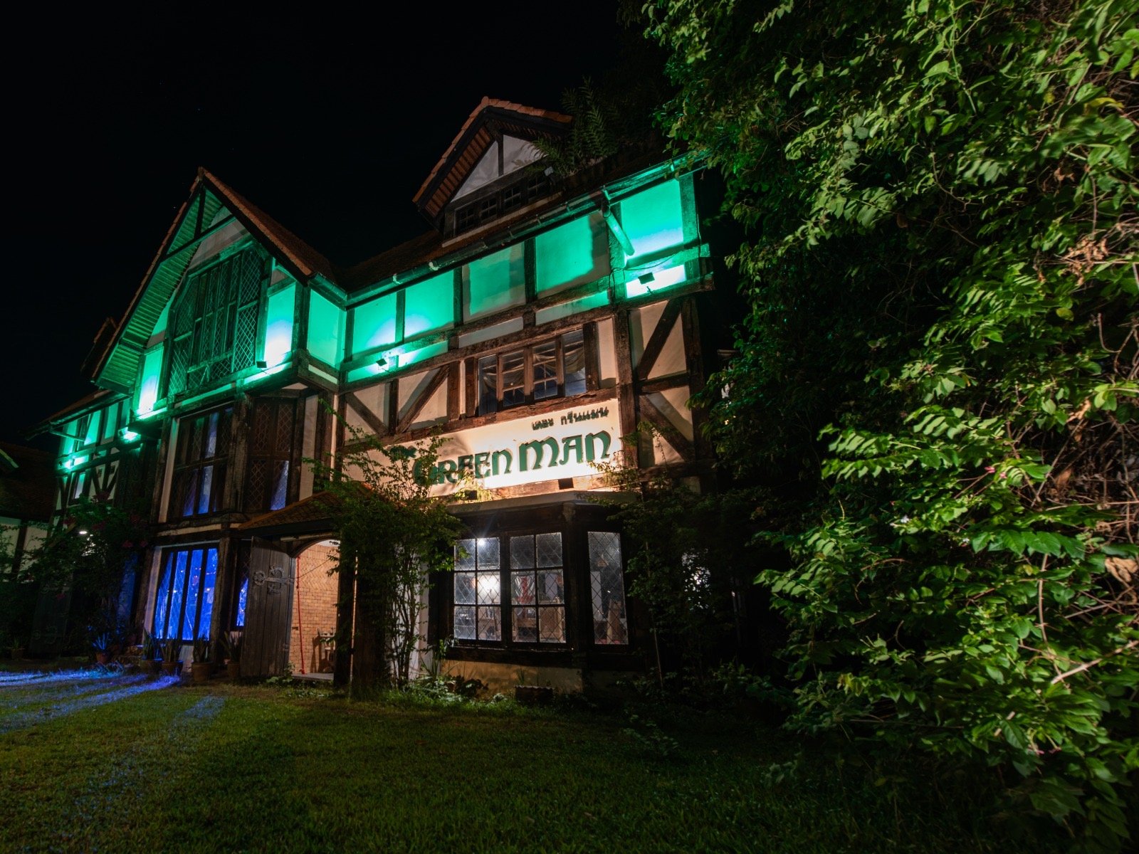 The Green Man pub illuminated at night with green lighting